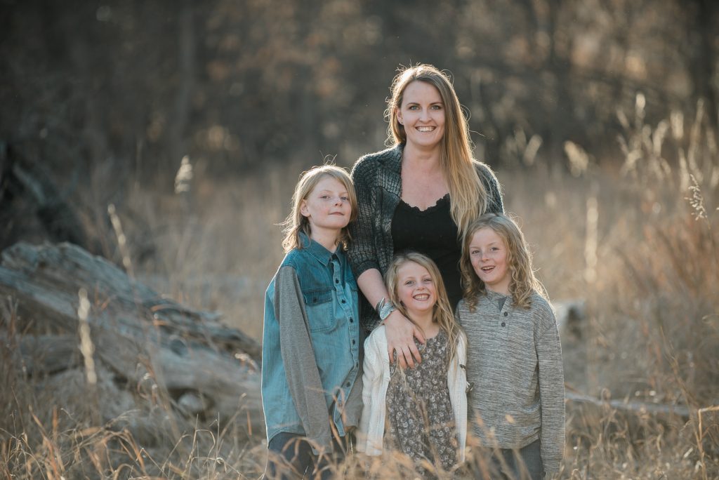 family smiling along the poudre river in fort collins, colorado