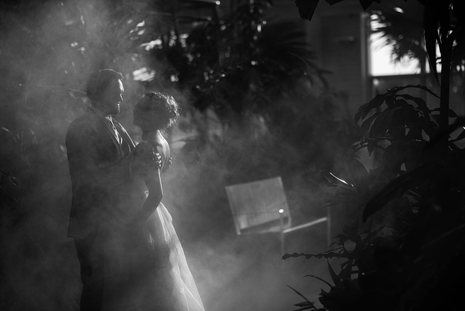 groom holding bride in fog