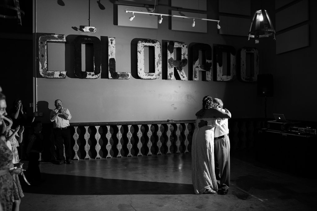 bride hugging dad under colorado sign