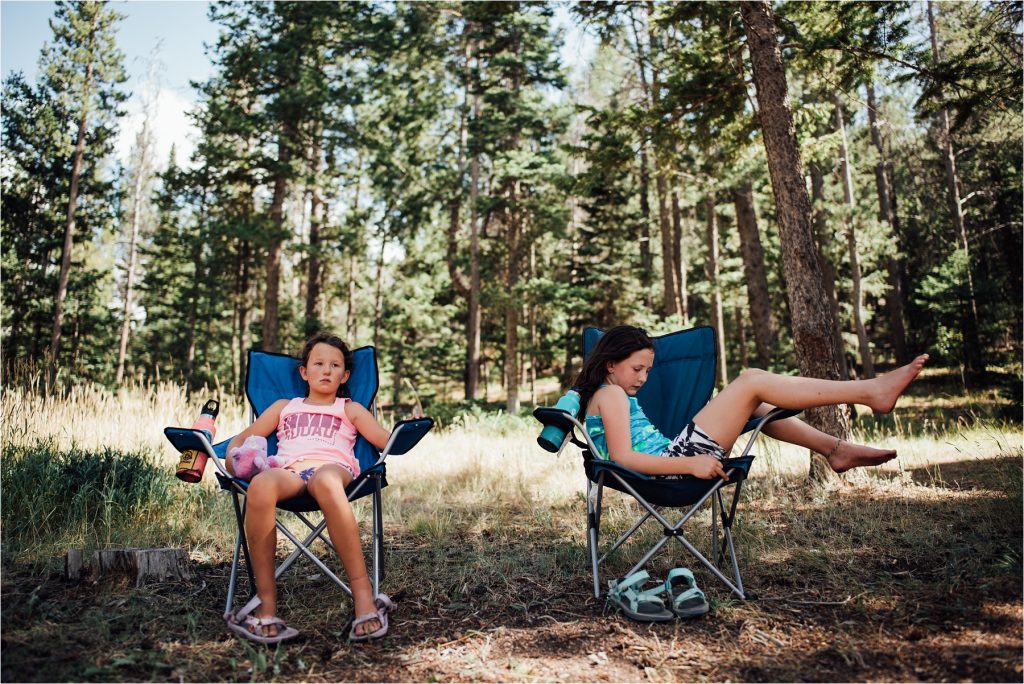 Kids sitting in chairs in forest.