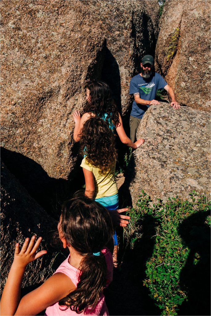 Kids climbing through boulders.