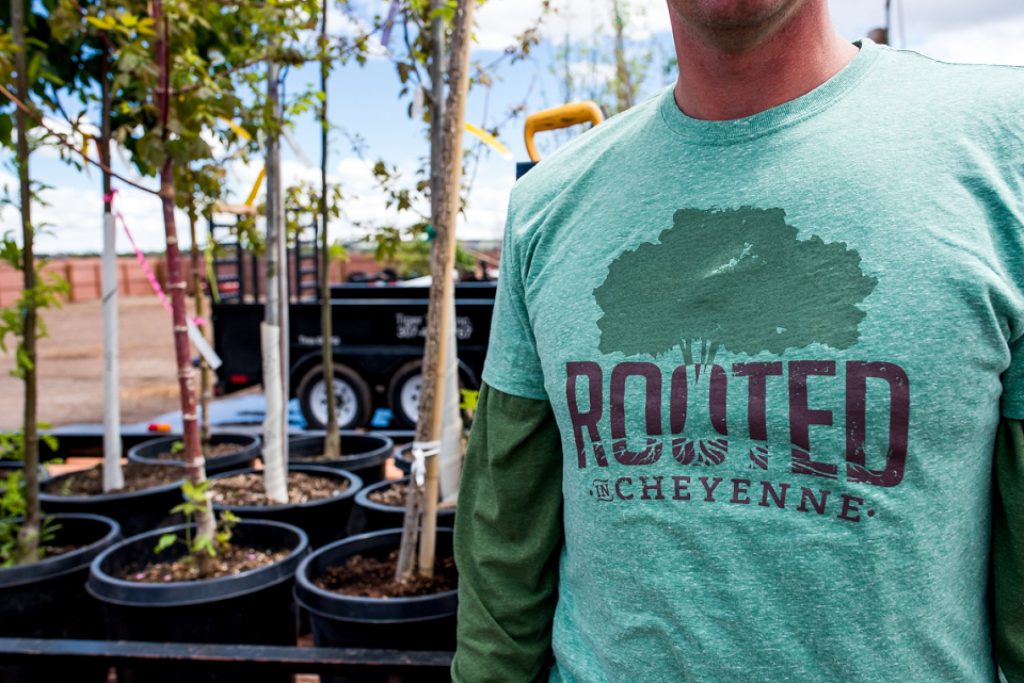 man wearing rooted in cheyenne shirt near trees
