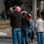 man in pink pussyhat taking photos at women's march in cheyenne