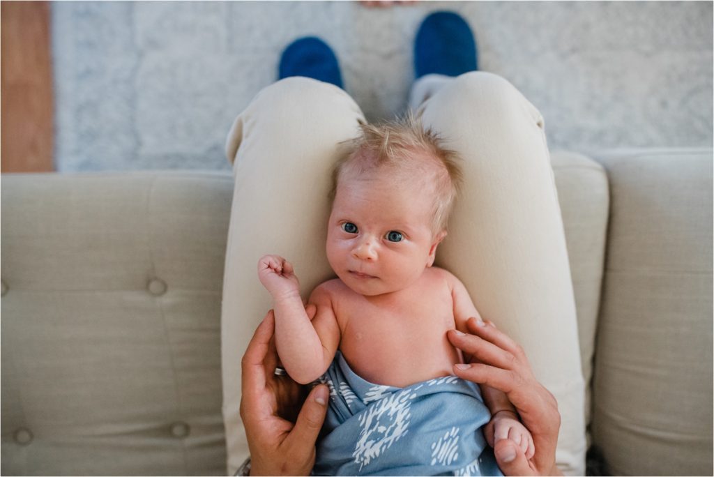 Dad holding newborn on lap.