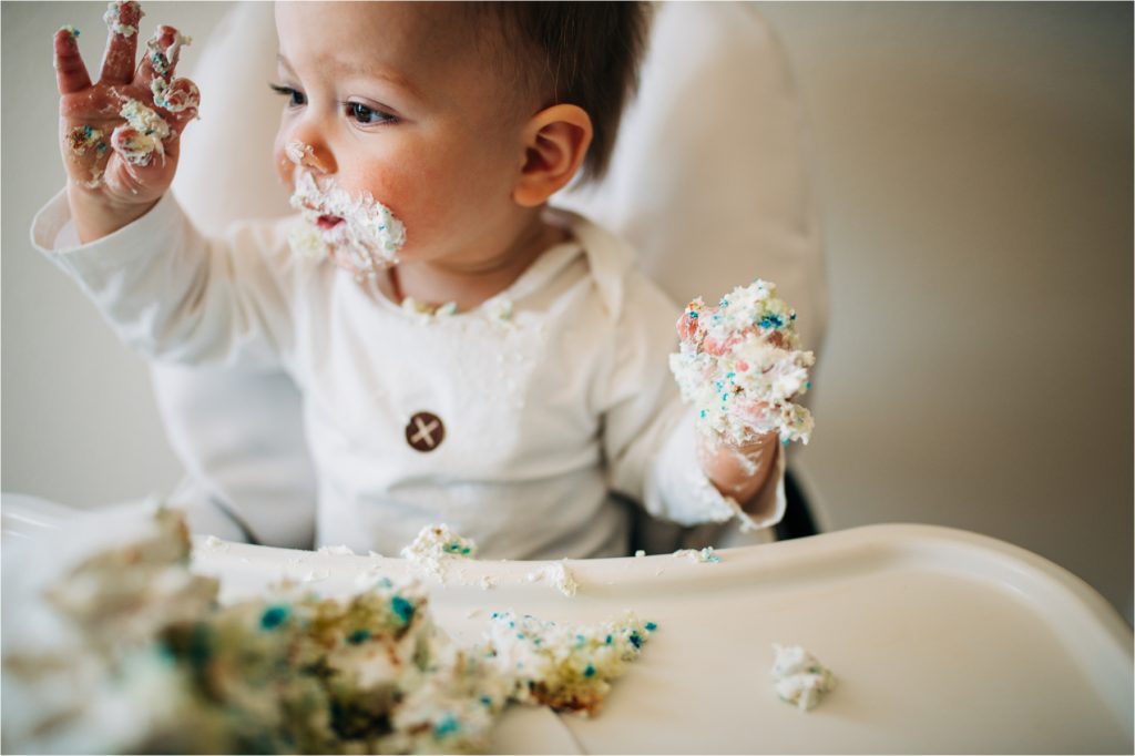 Baby with cake on hands