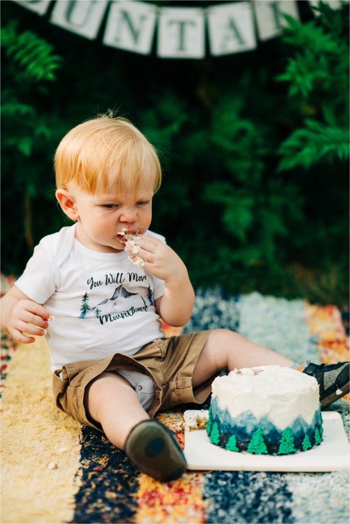 Boy scrunching up nose while eating birthday cake.