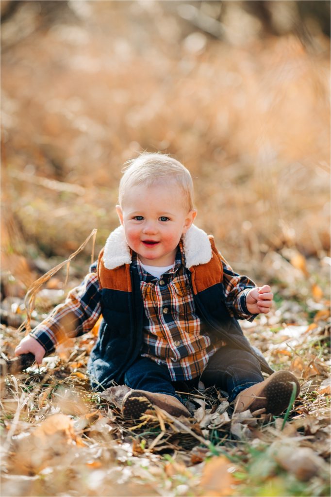 Baby boy laughing in tall grass in Fort Collins.