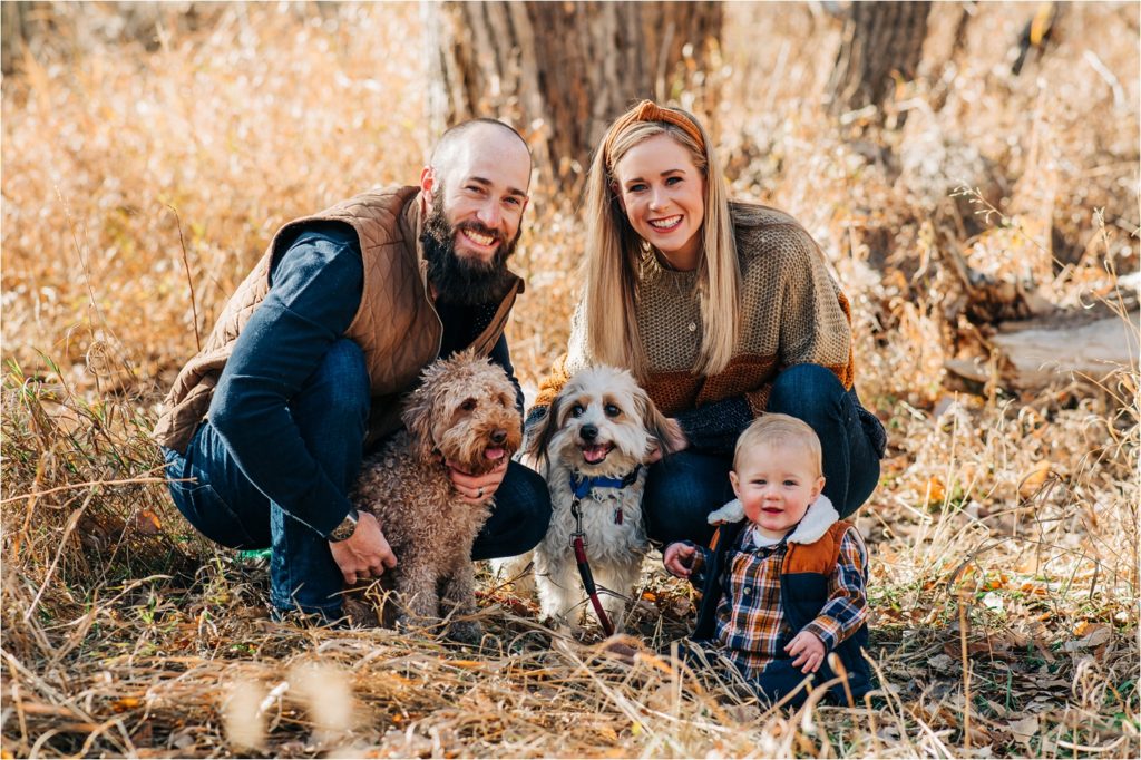 Family with dogs smiling during fort collins family photography session.